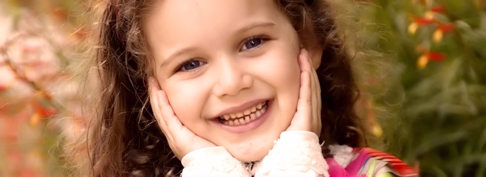 child with blue eyes holding her face slide