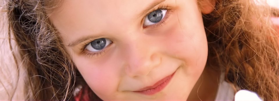 close up of blue eyed blond child slide